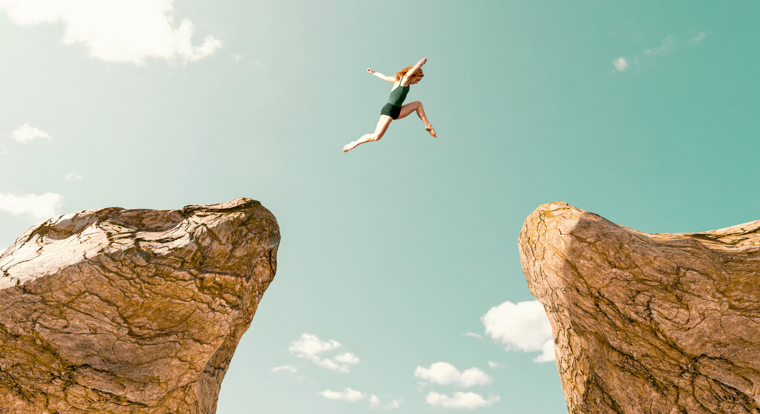 Woman makes dangerous jump between two rock formations